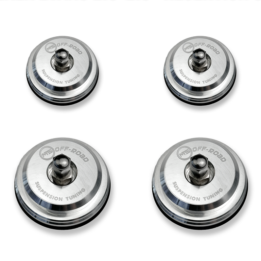 Four metallic suspension tuning components on a white background